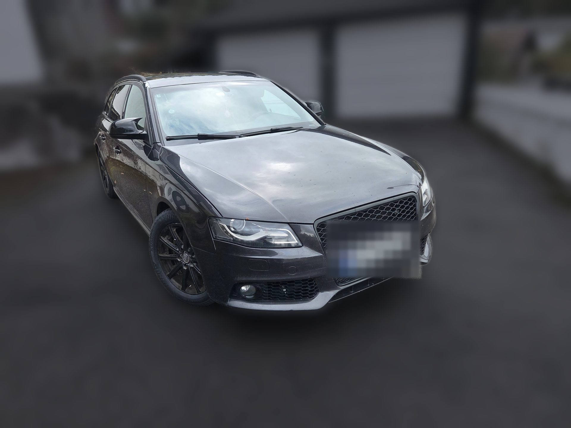 Grå Audi A4 Avant B8 sett skrått forfra med svart grill og svarte felger